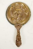 A C19th Art Nouveau bronze hand mirror embossed with scrolls and faces, and bejewelled glass mirror,