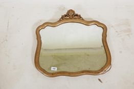 A giltwood wall mirror with shaped frame and carved crest, 22" x 20"