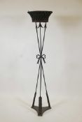 A wrought metal torchere with painted toleware liner, 58" high