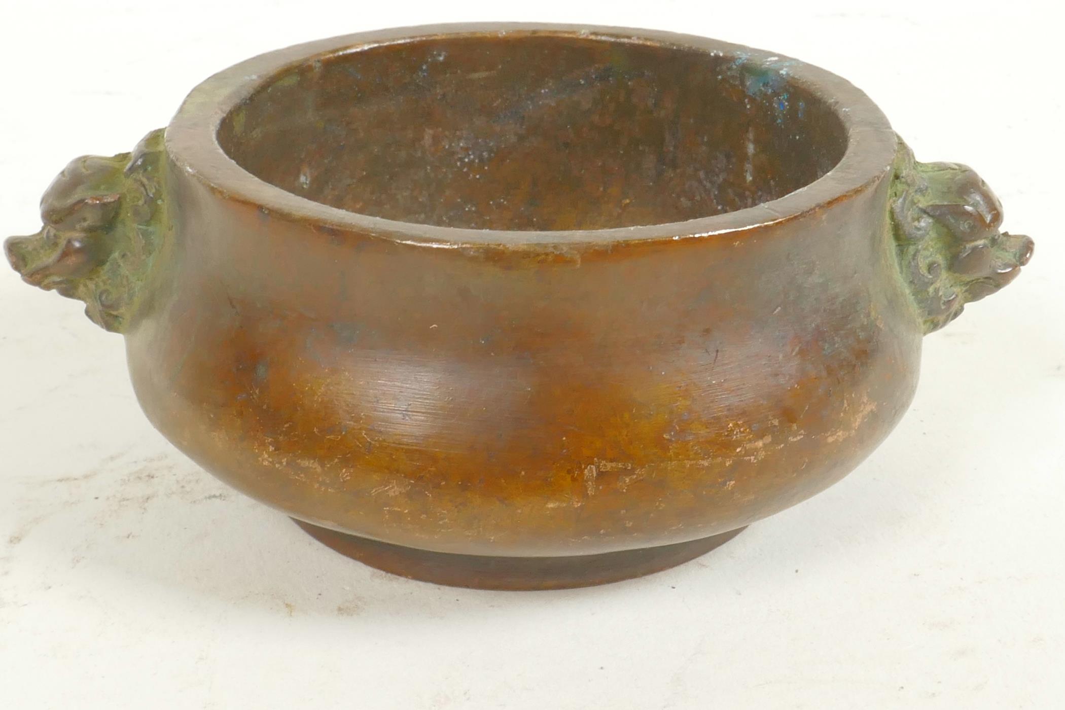 A Chinese miniature bronze censer with cast lion's mask handles, seal mark to base, 3" diameter