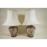 A pair of Chinese pottery table lamps on wood stands with white silk shades, 20" high