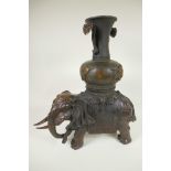 An oriental bronze figure of an ornately dressed elephant with a large vase on his howdah, 16½" high