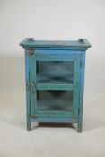 An Indian painted pine cabinet, with single glazed door and glazed sides, raised on stile