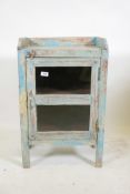 An Indian hardwood cabinet with three quarter gallery top and single glazed door, and distressed