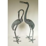 A pair of patinated metal garden figures of cranes, largest 32½" high