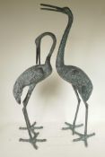 A pair of patinated metal garden figures of cranes, largest 32½" high