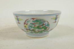 A Chinese carved doucai porcelain rice bowl with enamelled dragon decoration, 6 character mark to