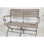 A wrought steel and teak slatted two seater folding garden bench labelled Smith and Hawken, Mill