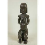 A stylised bronze figure of a seated African woman, 14" high