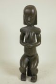 A stylised bronze figure of a seated African woman, 14" high