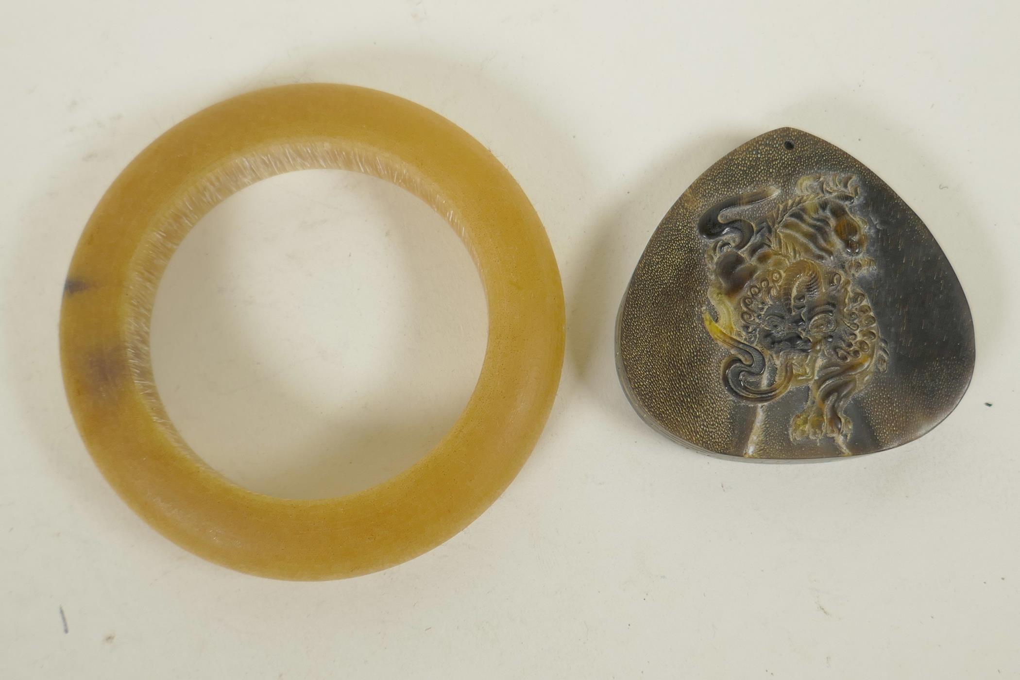 A Chinese faux horn bangle, and a horn pendant with carved kylin decoration, 3½" diameter - Image 2 of 2