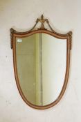 A mahogany and parcel gilt, shield shaped wall mirror, with urn crest and harebell swag