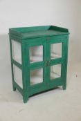 An Indian painted hardwood two door display cabinet with glazed sides and three quarter gallery top,