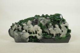 A Chinese marbled green hardstone ornament with carved decoration of travellers, 10" wide