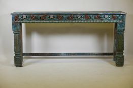 An Indian hardwood low table, with carved frieze and metal strap mounts, raised on turned supports