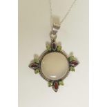 A silver pendant necklace set with a large moonstone, tourmaline and garnets, 3" drop