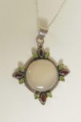 A silver pendant necklace set with a large moonstone, tourmaline and garnets, 3" drop