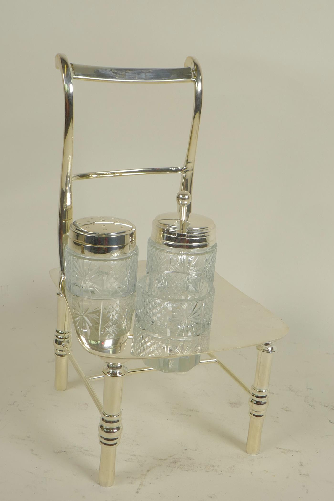 A silver plated cruet, the stand in the form of a bar back chair, 8" high