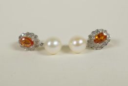 A pair of 9ct gold earrings set with an orange topaz encircled by diamonds, and pearl drop