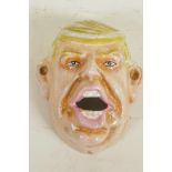 A cast iron wall mounted bottle opener cast as Donald Trump, 4" long