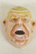 A cast iron wall mounted bottle opener cast as Donald Trump, 4" long