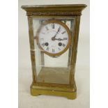 An American brass cased four glass mantel clock with twin train movement striking on a gong, white