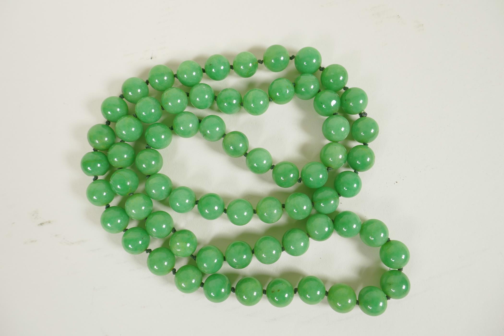 A string of light green jade beads, 34" long
