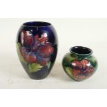 Two Moorcroft vases, a mid C20th Moorcroft 'Hibiscus' pattern squat vase, tube-lined flowers and