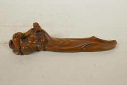 A Chinese boxwood incense stick holder in the form of a reclining sage, 8" long