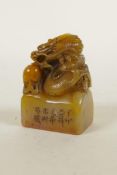 A Chinese carved soapstone seal with dragon and flaming pearl decoration, 2" high