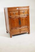 A Chinese fruitwood cupboard with two drawers over two doors, 25" x 20", 34" high
