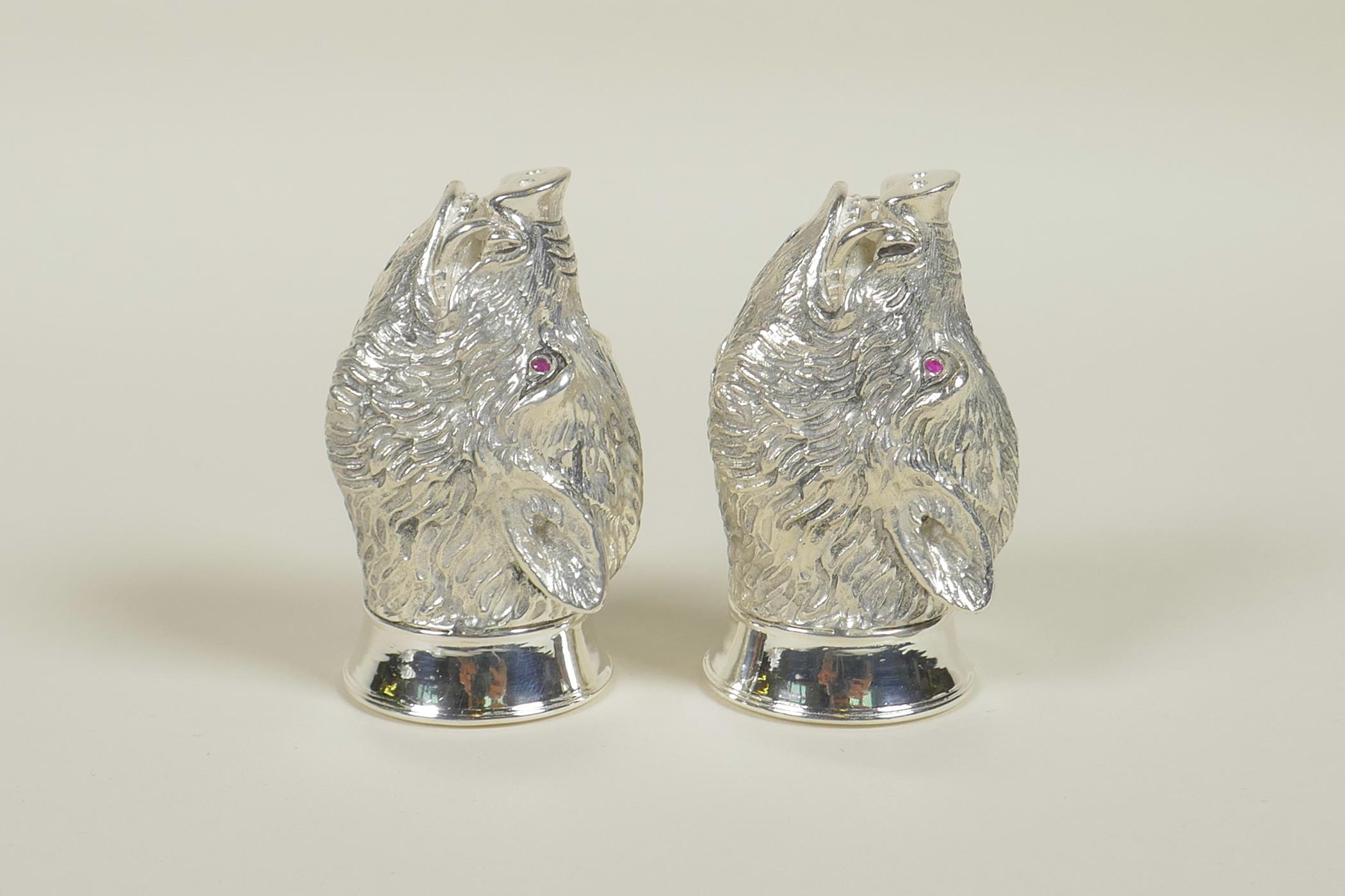 A pair of silver plated salt and pepper cruets in the form of boars' heads, 2" long
