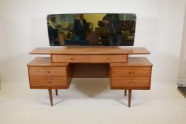 A 1970s 'Austinsuite' teak mirror back dressing table with a floating top and six drawers, 8" x