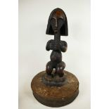 An African carved hardwood figure mounted as the handle to a large lid, 19" high