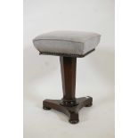 A Victorian mahogany revolving piano stool, raised on a tapering octagonal column and platform