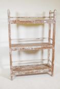 An Indian hardwood three tier open shelf with distressed paintwork, 35" x 12" x 54"