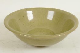 A Chinese celadon glazed porcelain bowl with central floral decoration, 7" diameter