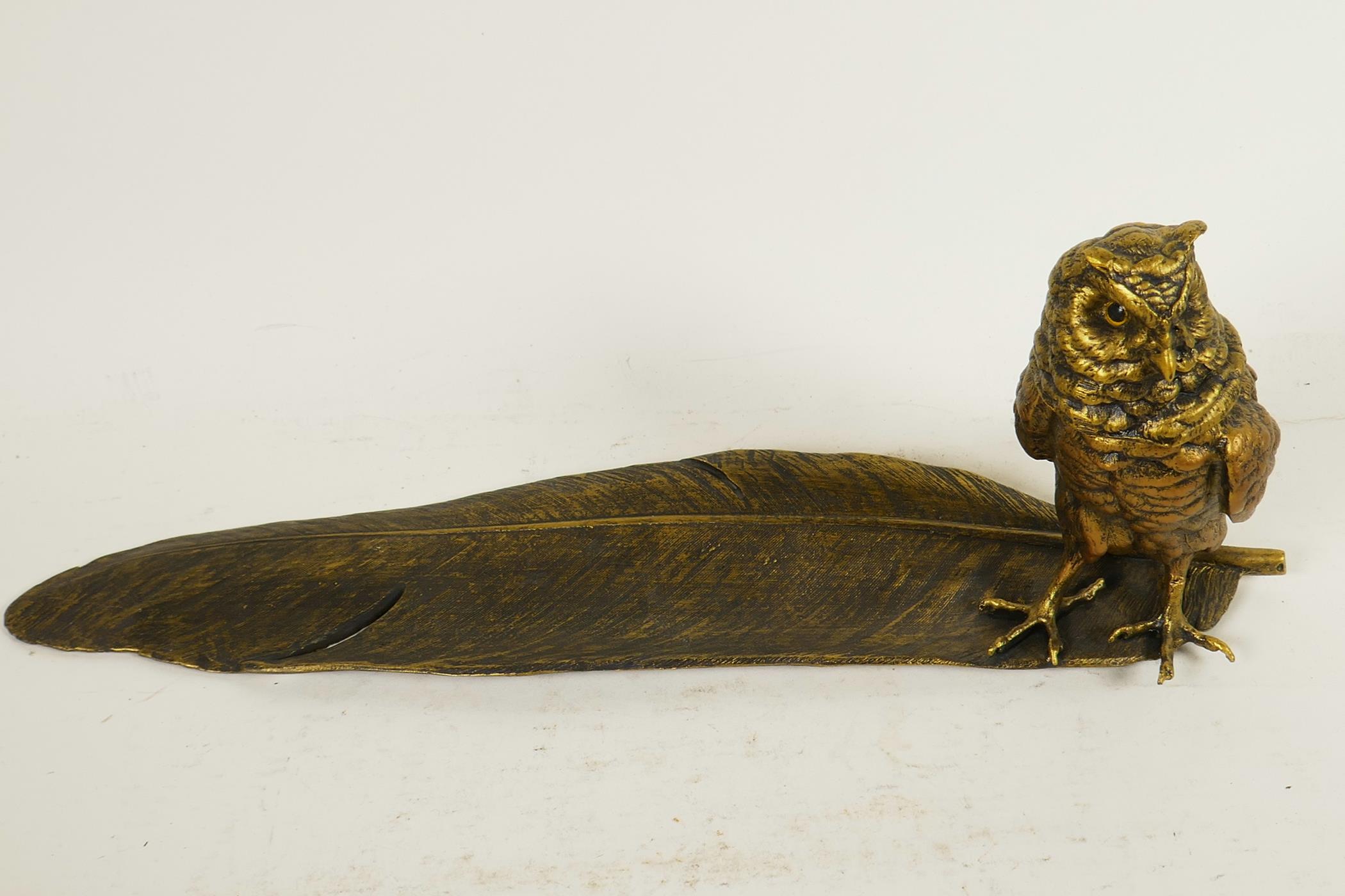 A bronze pen tray and inkwell cast as an owl standing on a large feather, 13½" long