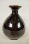 A Japanese treacle glazed pottery wine flask of bulbous form with character inscription to base, 6¼"