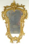 A Rococo style gilt framed wall mirror with carved scrolling frame, A/F, 16" x 29"