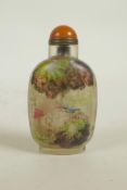 A Chinese reverse decorated glass snuff bottle depicting figures in a mountain landscape and