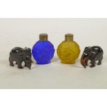 Two miniature carved faux tortoiseshell elephants, together with two coloured glass scent bottles,