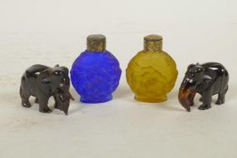 Two miniature carved faux tortoiseshell elephants, together with two coloured glass scent bottles,