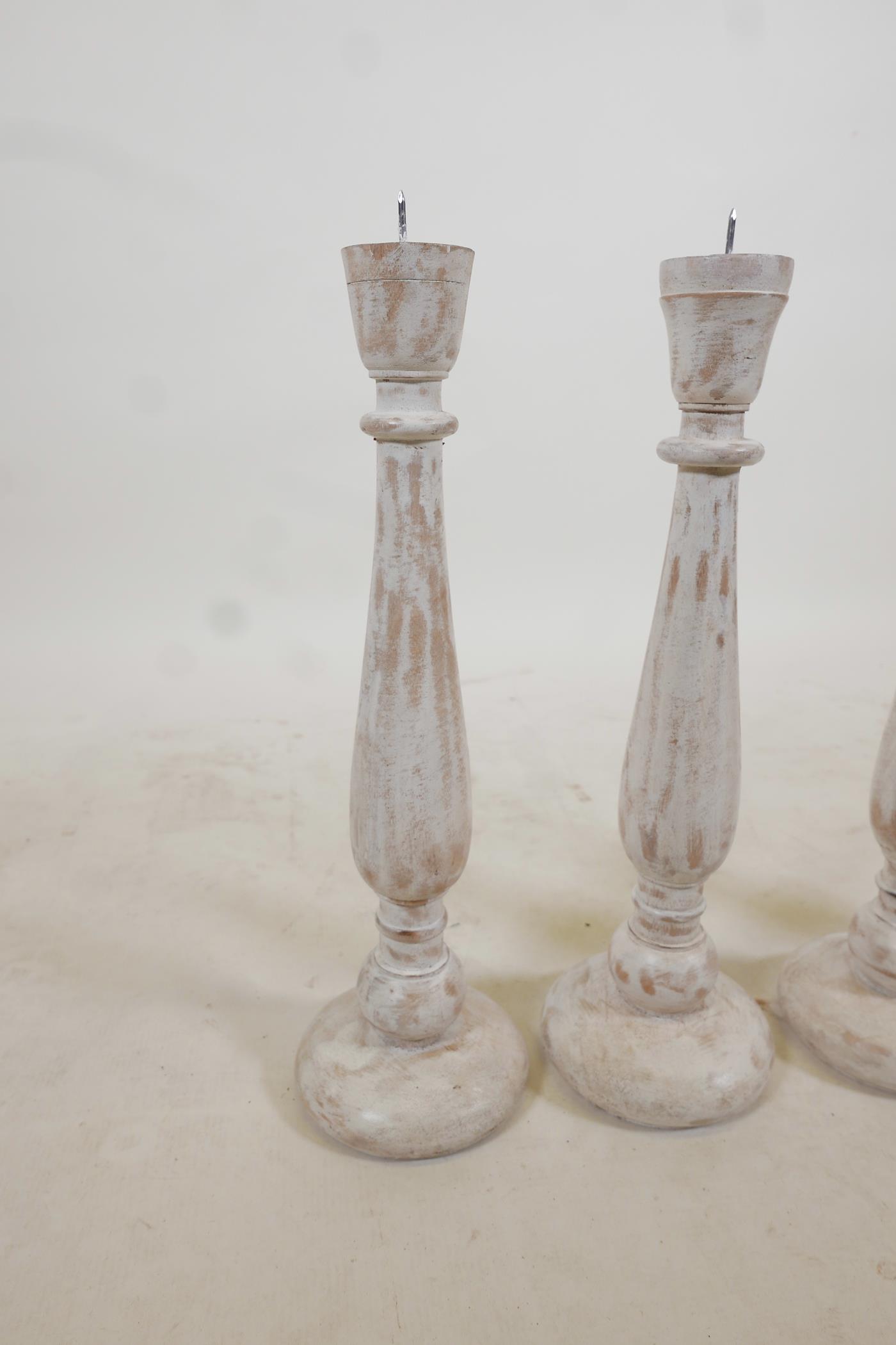 A set of four turned and painted wood pricket candlesticks with a distressed finish, 19" high - Image 2 of 2