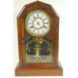 A walnut cased mantel clock with twin train movement striking on a gong, with mercury pendulum,