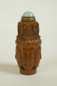 A Chinese soapstone snuff bottle with carved four Buddha head decoration, 3" high