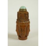 A Chinese soapstone snuff bottle with carved four Buddha head decoration, 3" high