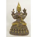 A Sino-Tibetan brass figure of a monk seated in meditation, 9" high