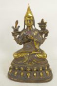 A Sino-Tibetan brass figure of a monk seated in meditation, 9" high