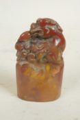 A small Chinese carved soapstone seal, the top carved as a mythical beast, 2½" long